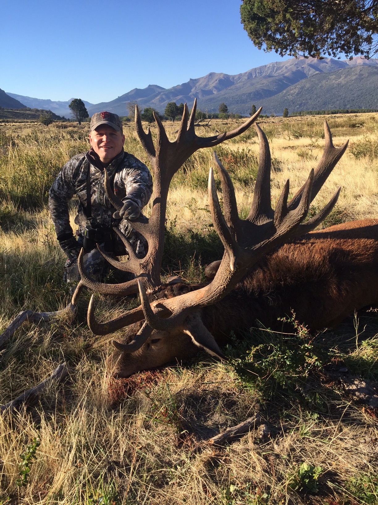 Hunter holding the antlers of a mature Patagonian red stag