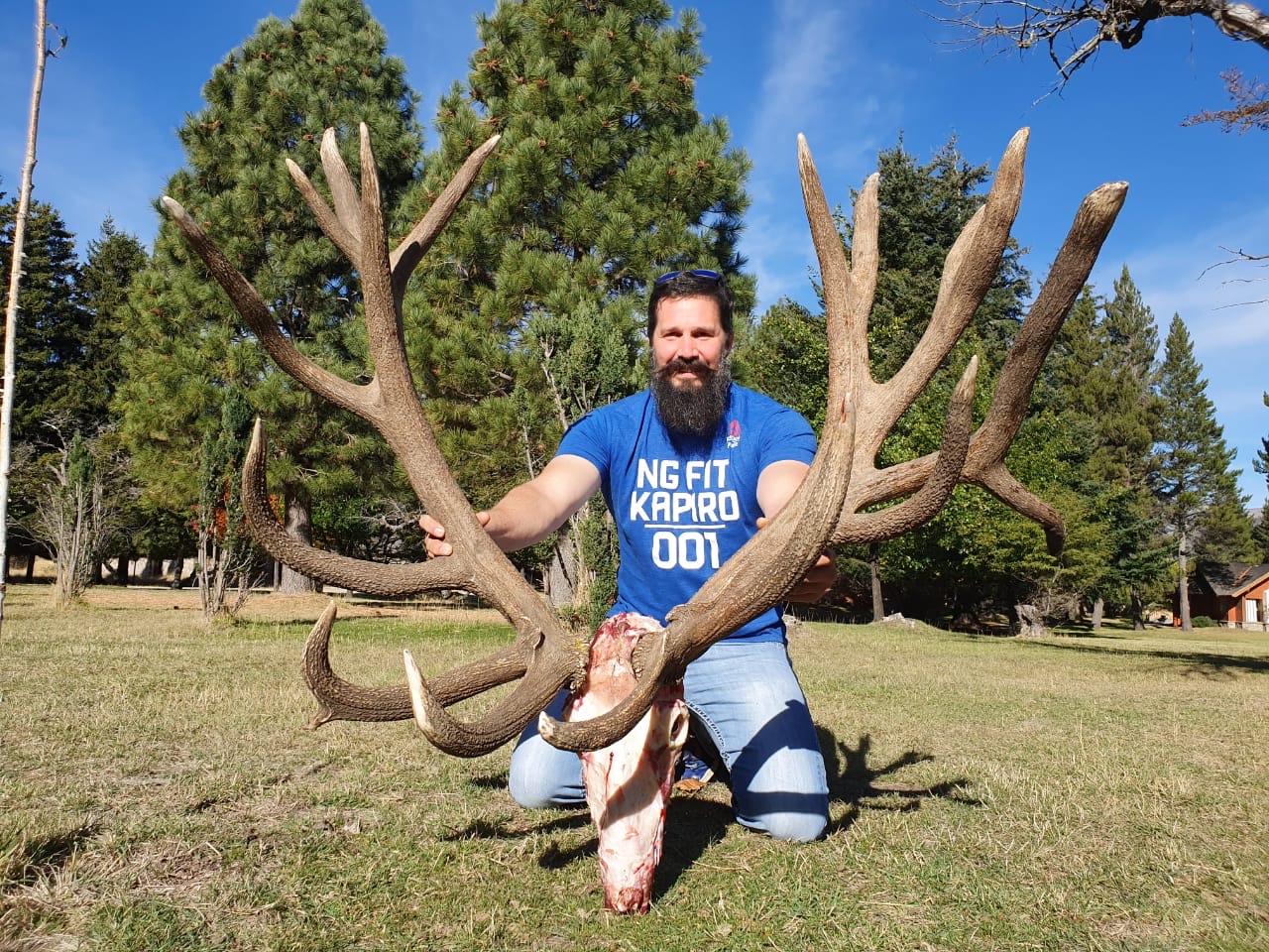 Hunter displaying a European-mounted red stag skull and antlers