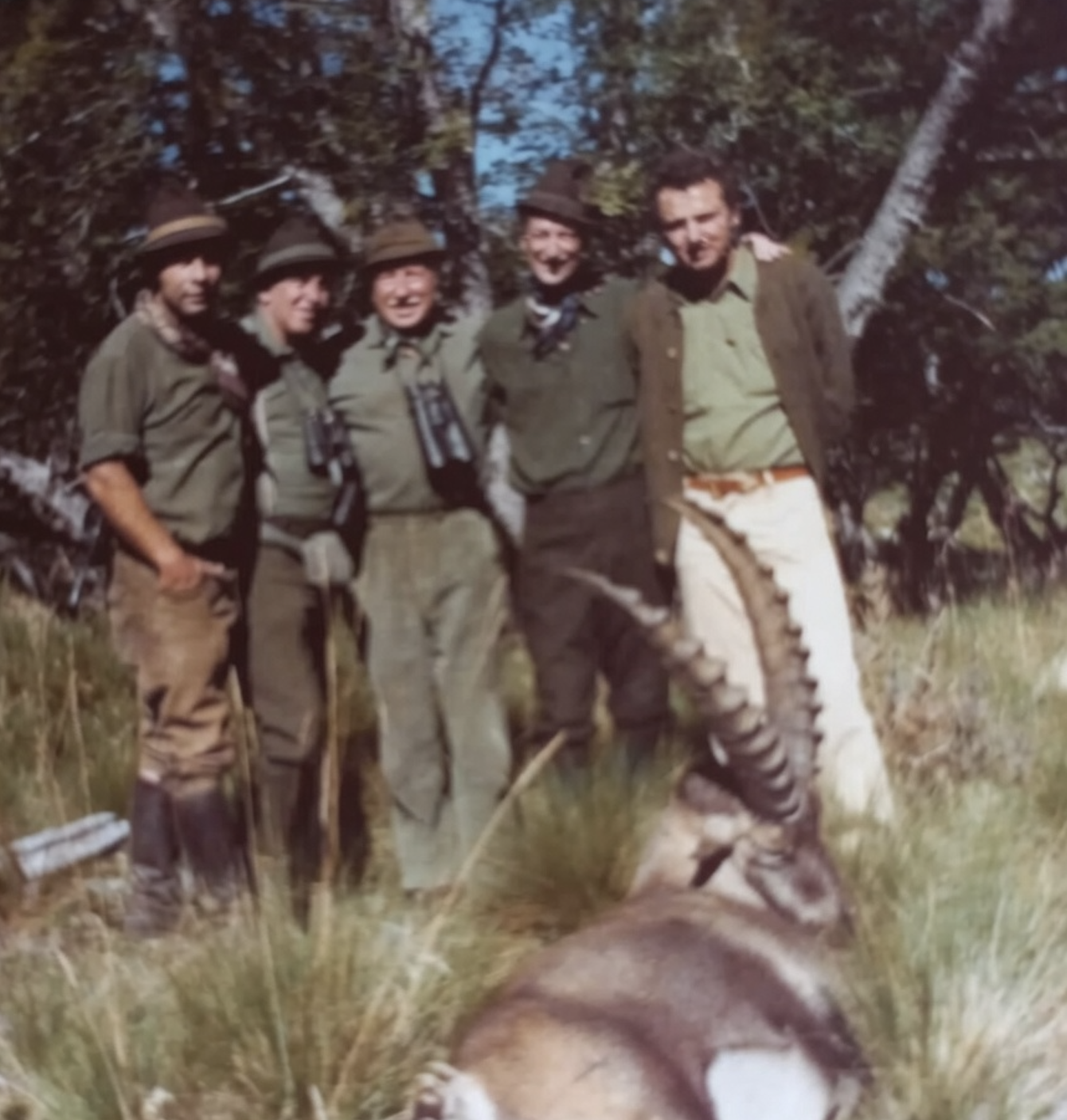 1972 archive photograph of Dr. Carl Adolf Vogel and the Parque Diana men standing behind an Alpine ibex in the Patagonian forest