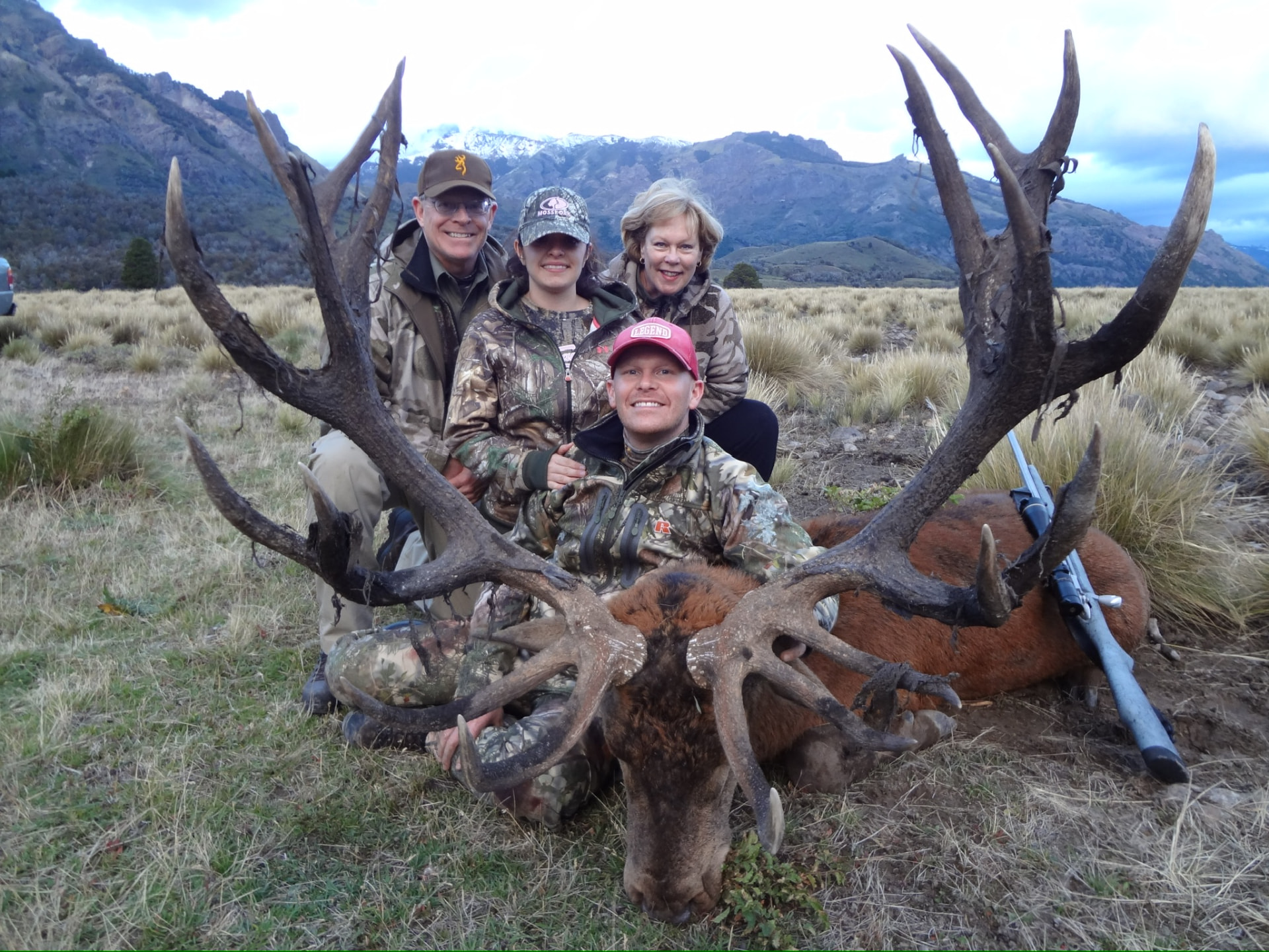 Family of hunters behind a massive Patagonian red stag