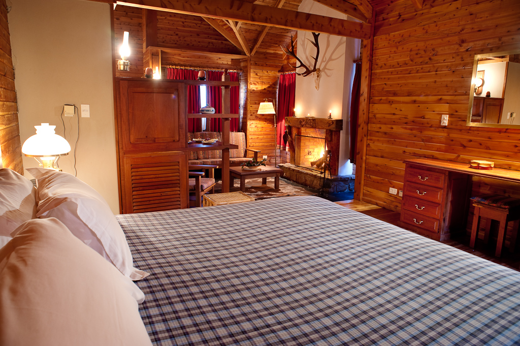 Cabin bedroom at Parque Diana with a lit fireplace