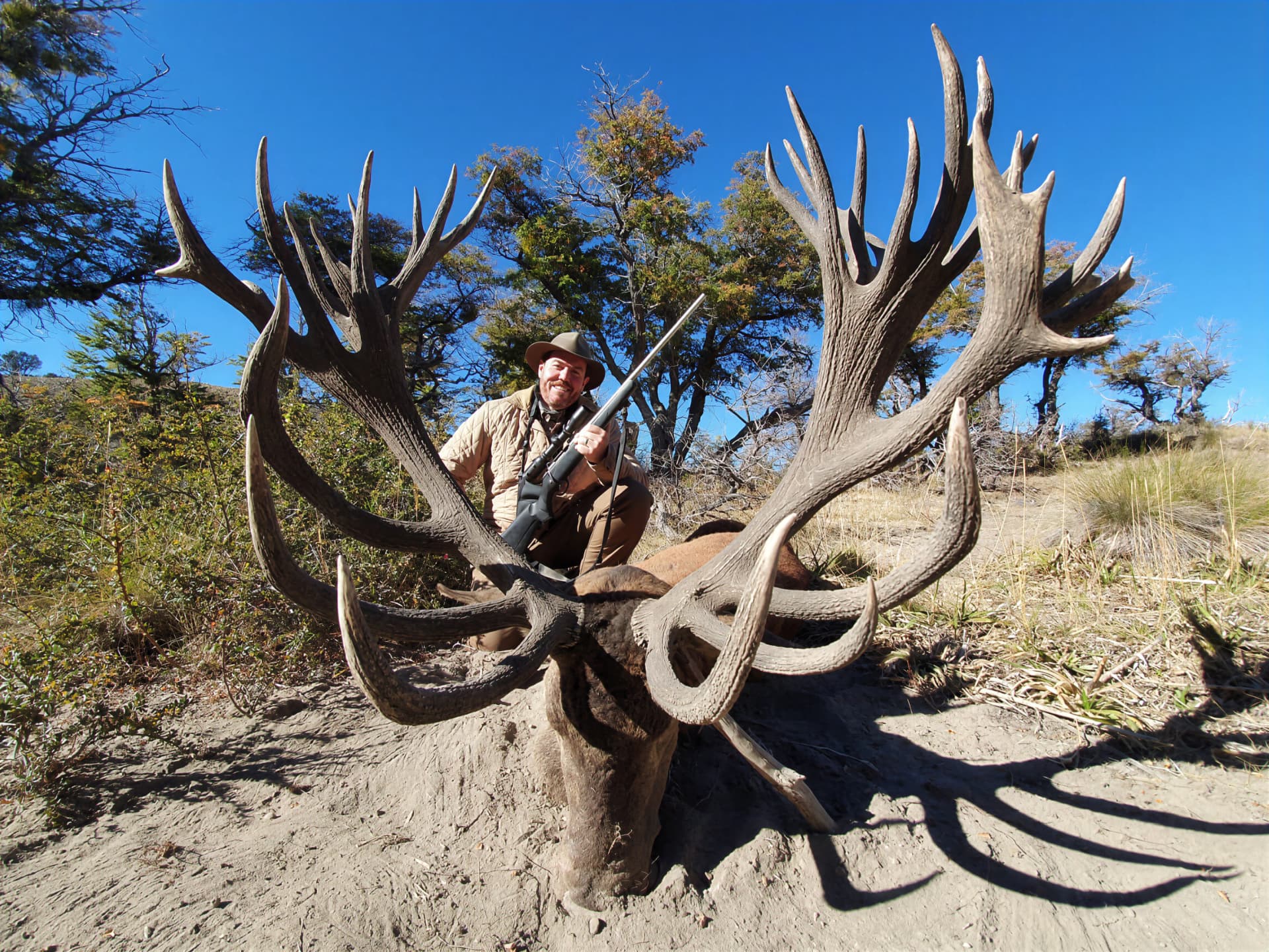 Hunter behind an exceptionally wide gold-medal Patagonian red stag