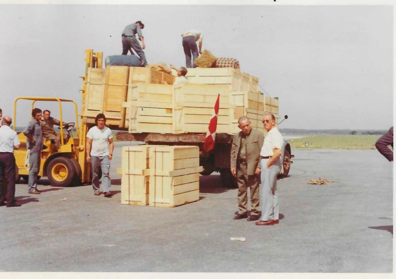 Archival photograph of wooden crates of European game being unloaded from a truck at the airfield before the voyage to Patagonia