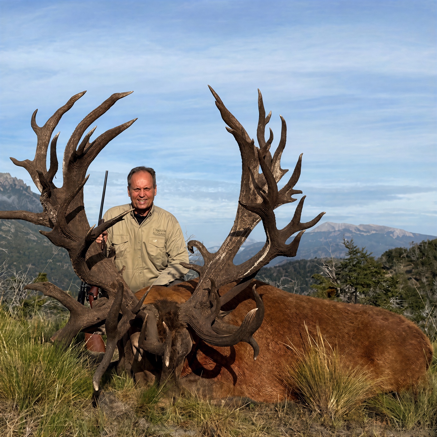 Hunter with an enormous multi-tined Patagonian red stag high in the Andes